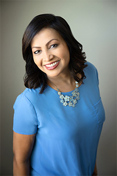 A woman with a smile, posing for a portrait.