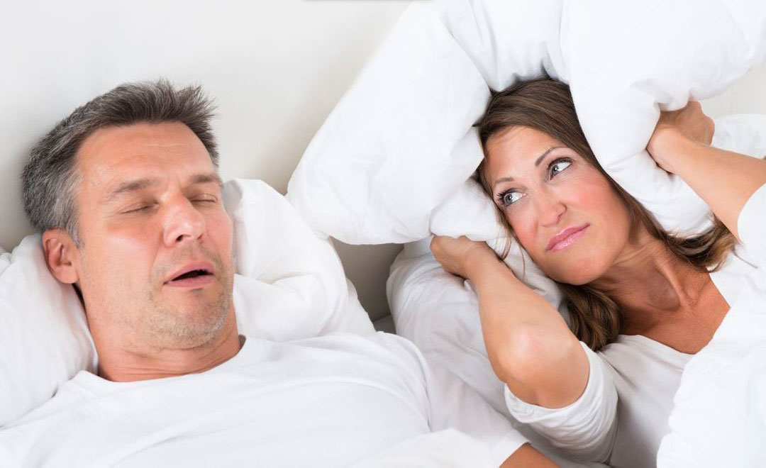 A man and a woman sleeping peacefully, each with their own pillow.