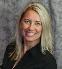 A woman with short hair is smiling and posing for a portrait.